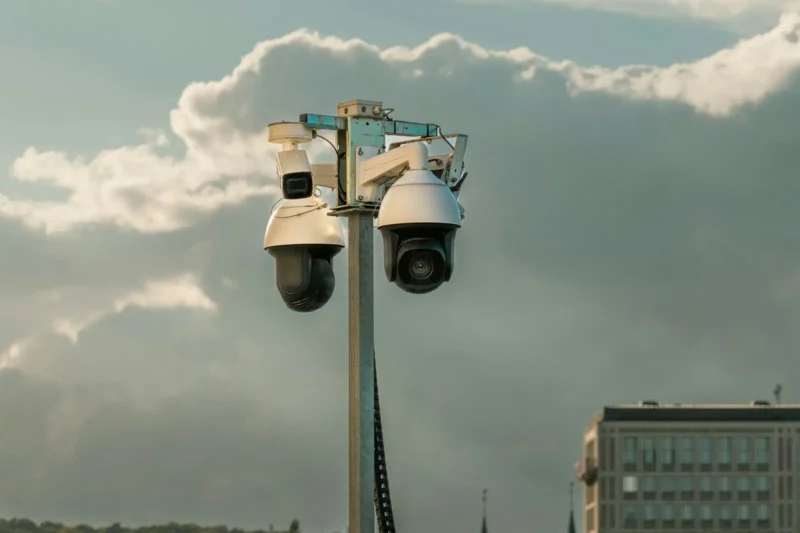 CCTV cameras mounted on a pole against a cloudy sky