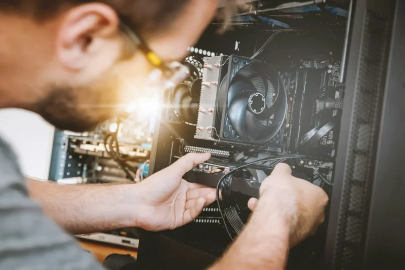 IT technician installing components inside a computer
