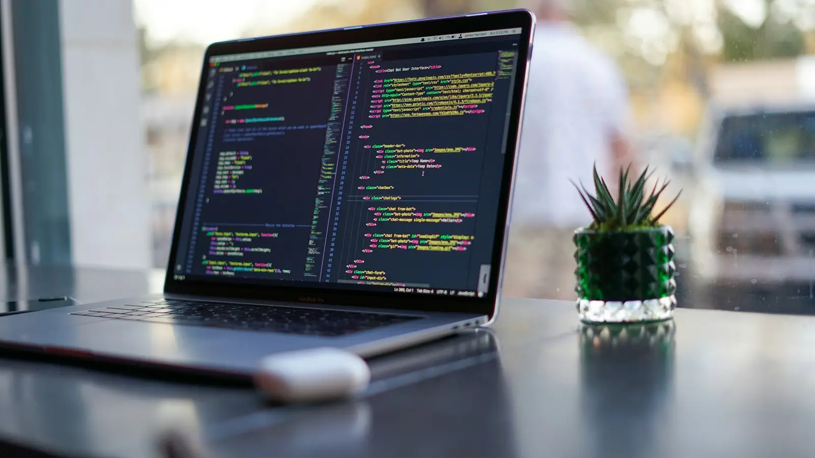Laptop showing website code on a desk